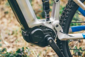 Detailed view of an electric mountain bike crank arm and frame outdoors.