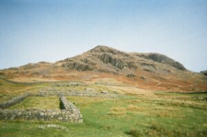 Ruins of Hardknott Fort with a mountainous backdrop in England's Lake District.