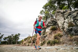 Elderly man with trekking poles enjoying a trail run in a forest area of Balıkesir, Türkiye.