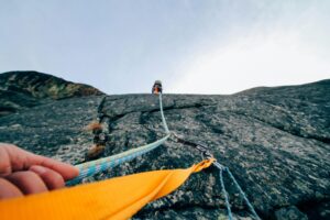 Capture the thrill of rock climbing with this dynamic low-angle shot showcasing determination and teamwork.