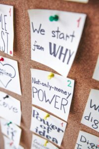 Close-up of motivational sticky notes with messages on a cork board.