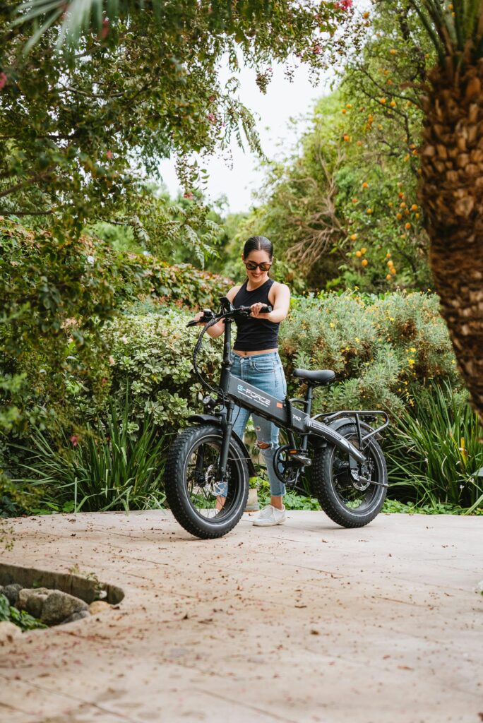 Woman enjoys a peaceful ride in a lush green park with electric bicycle.