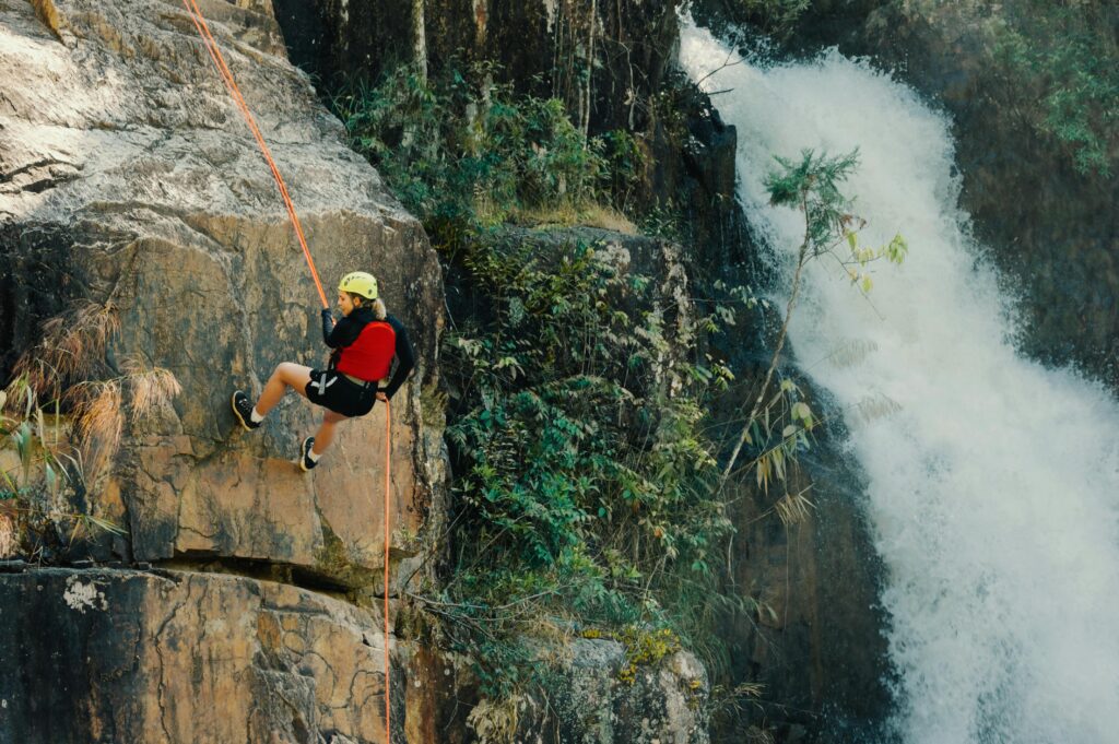 Thrilling outdoor rock climbing by a waterfall showcasing adventure and nature.