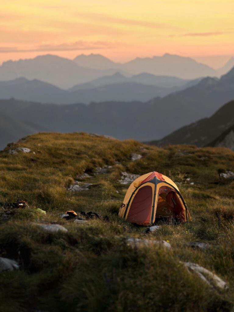 Enchanting sunset view with a tent in Austria's mountains, ideal for outdoor adventure.